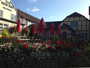 A traditional English pub with a sign reading "The New Inn" and "Hotel Reception" visible.