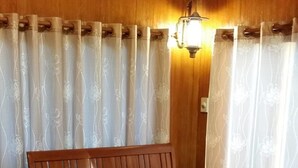 Un canapé et une table basse en bois, dans une pièce aux murs en bois et au plafond en pente.