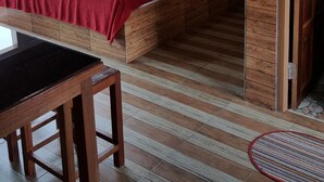 Une pièce en bois avec un lit, une table et une fenêtre.