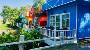 Une rangée de maisons aux couleurs vives, avec une clôture blanche au premier plan.