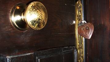 A wooden door with a brass doorknob and a heart-shaped keychain with the number 19.