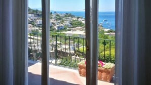 Un balcón con vistas a un pueblo costero y al mar.
