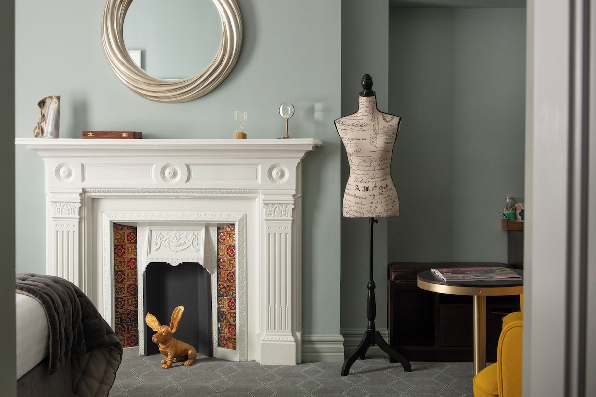 A room with a fireplace, a mannequin, and a rabbit figurine.