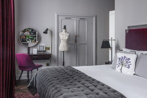 A bedroom with a bed, a chair, a wardrobe, and a desk with a mirror. - The Wilder (Dublin)