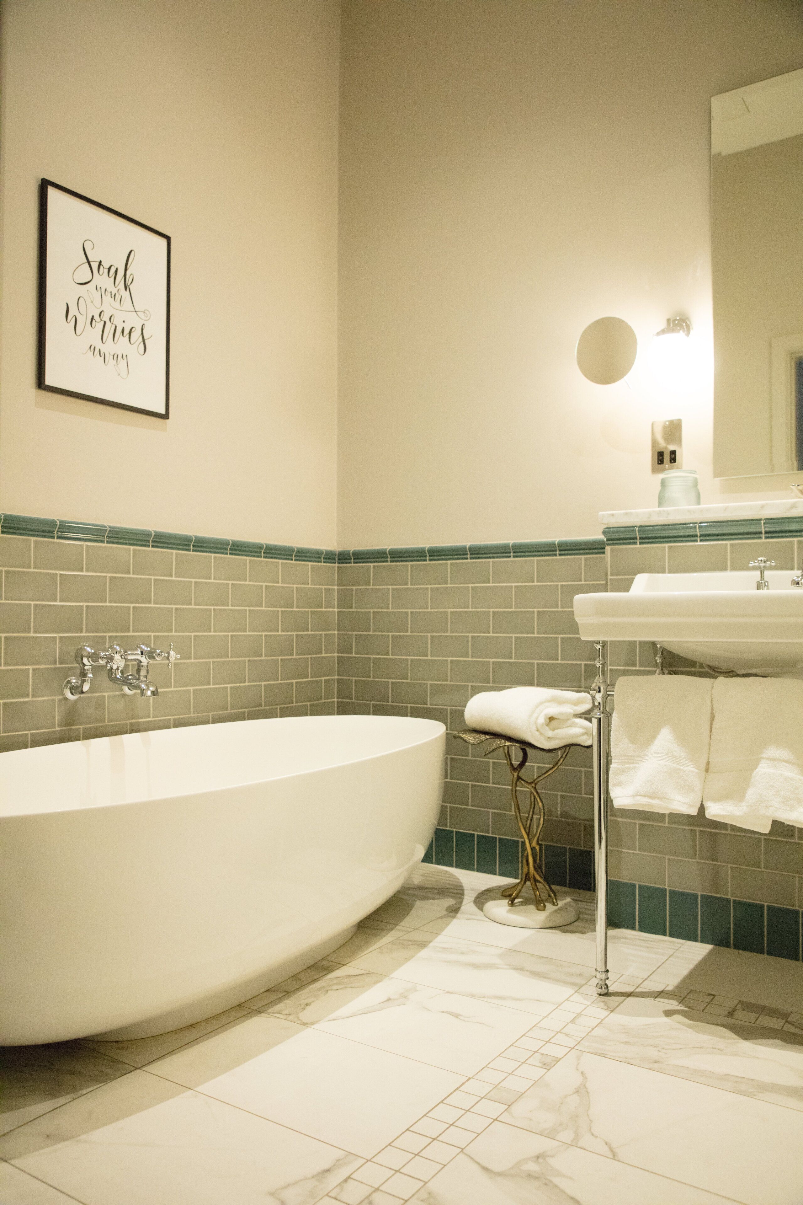 A modern bathroom with a freestanding bathtub, a sink, and a towel rack.