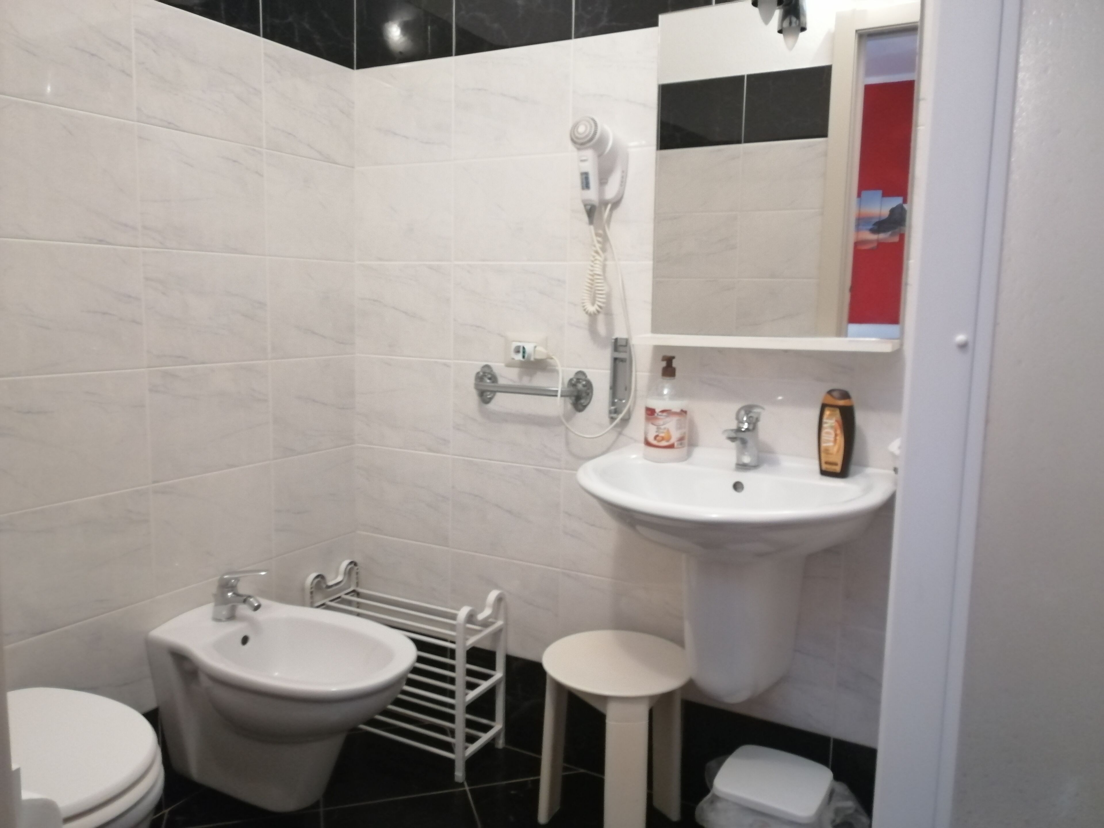Un baño con bidé, lavabo, espejo y retrete.