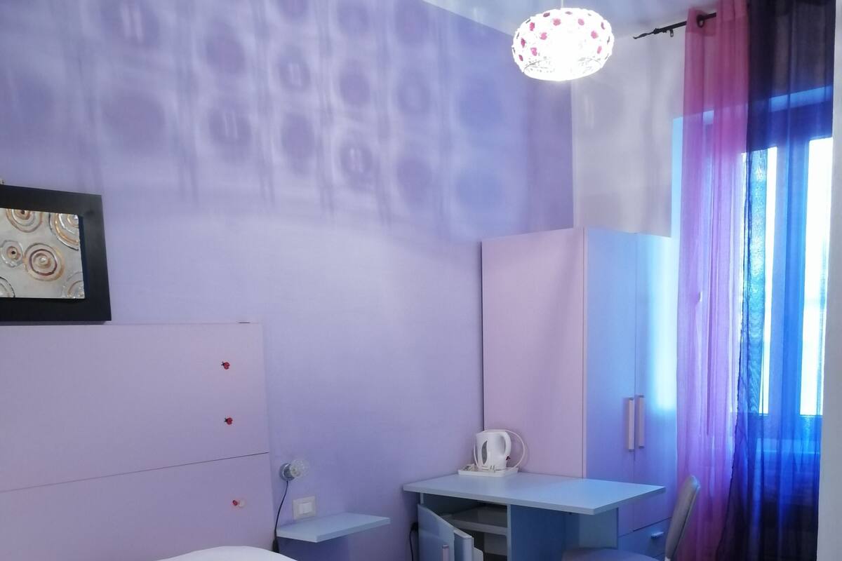 Un dormitorio con cama, escritorio y silla.