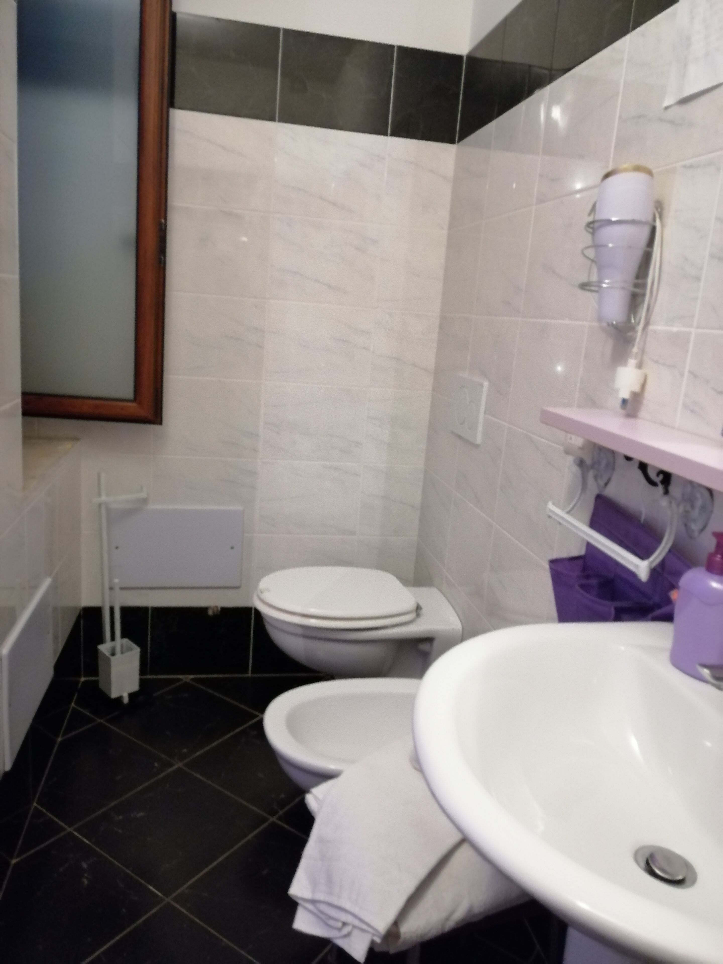 Un bagno con WC, bidet e lavandino.