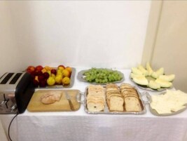 Un tavolo da buffet con diversi cibi, tra cui frutta, pane e formaggio.