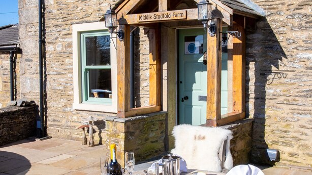 A stone building with a sign reading "Middle Studfold Farm." - Middle Studfold Farm B&B (Settle)