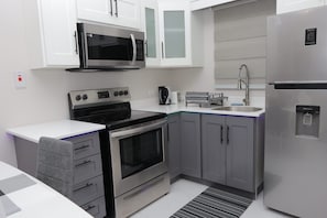 Suite estudio ejecutiva, 1 cama King size, cocina | Cocina privada | Microondas, horno tostador, utensilios de cocina y toallas de papel