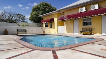 Una piscina al aire libre, sillones reclinables de piscina