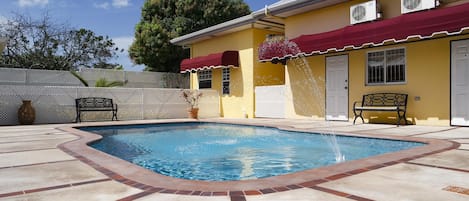 Una piscina al aire libre, sillones reclinables de piscina