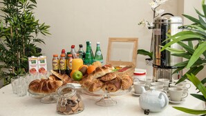 A breakfast table with croissants, fruits, and beverages. - Château Rieutort (Saint-Pargoire)