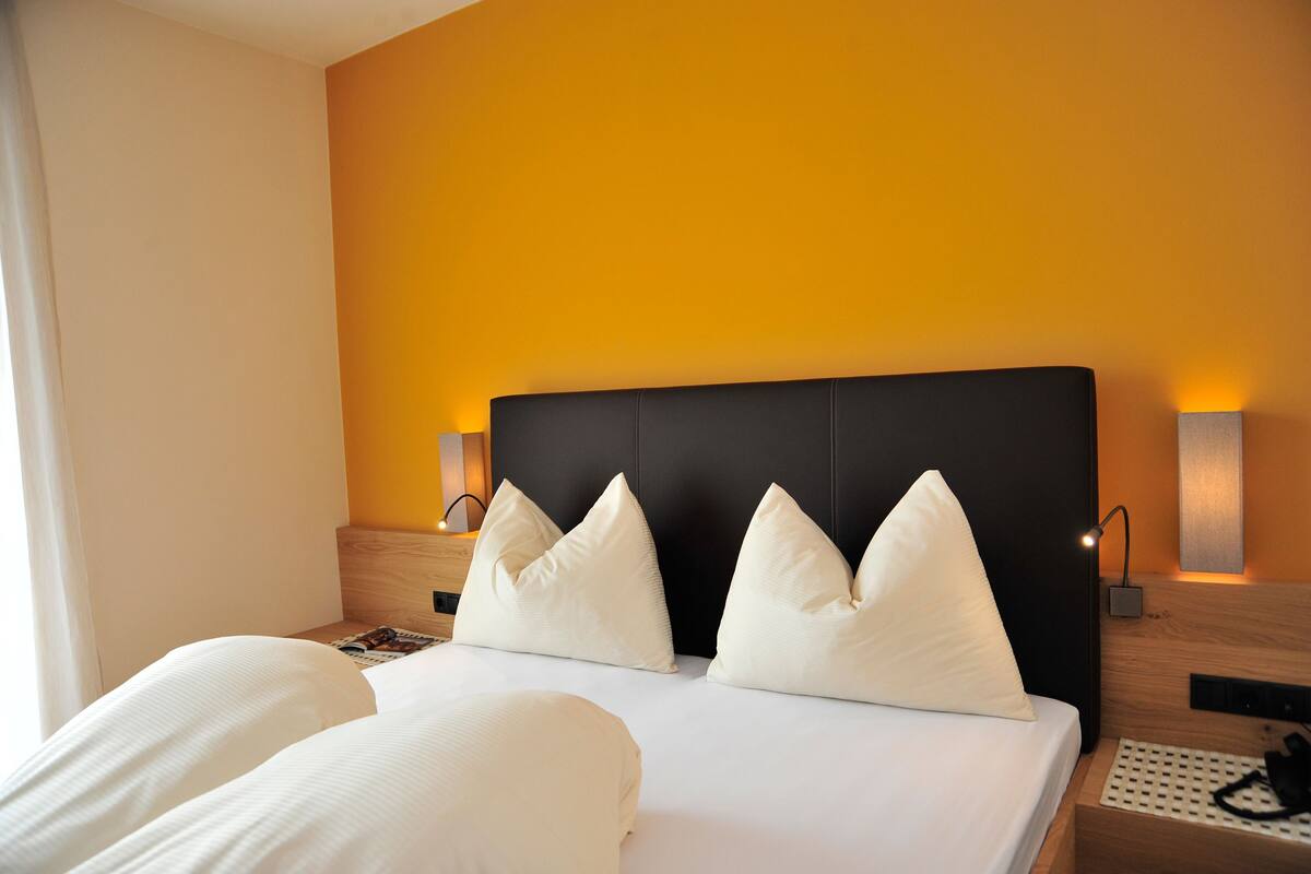 Ein Hotelzimmer mit einem großen Bett, zwei Nachttischen und zwei Wandleuchten.
