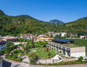 Un quartier résidentiel avec des maisons, un parc verdoyant et un bâtiment moderne doté d’un toit plat.