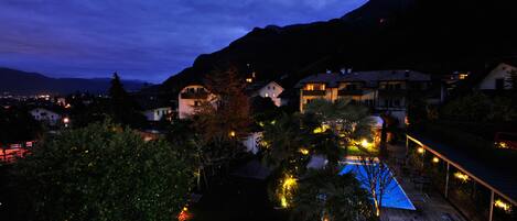 A residential area with houses, a swimming pool, and a mountain backdrop.