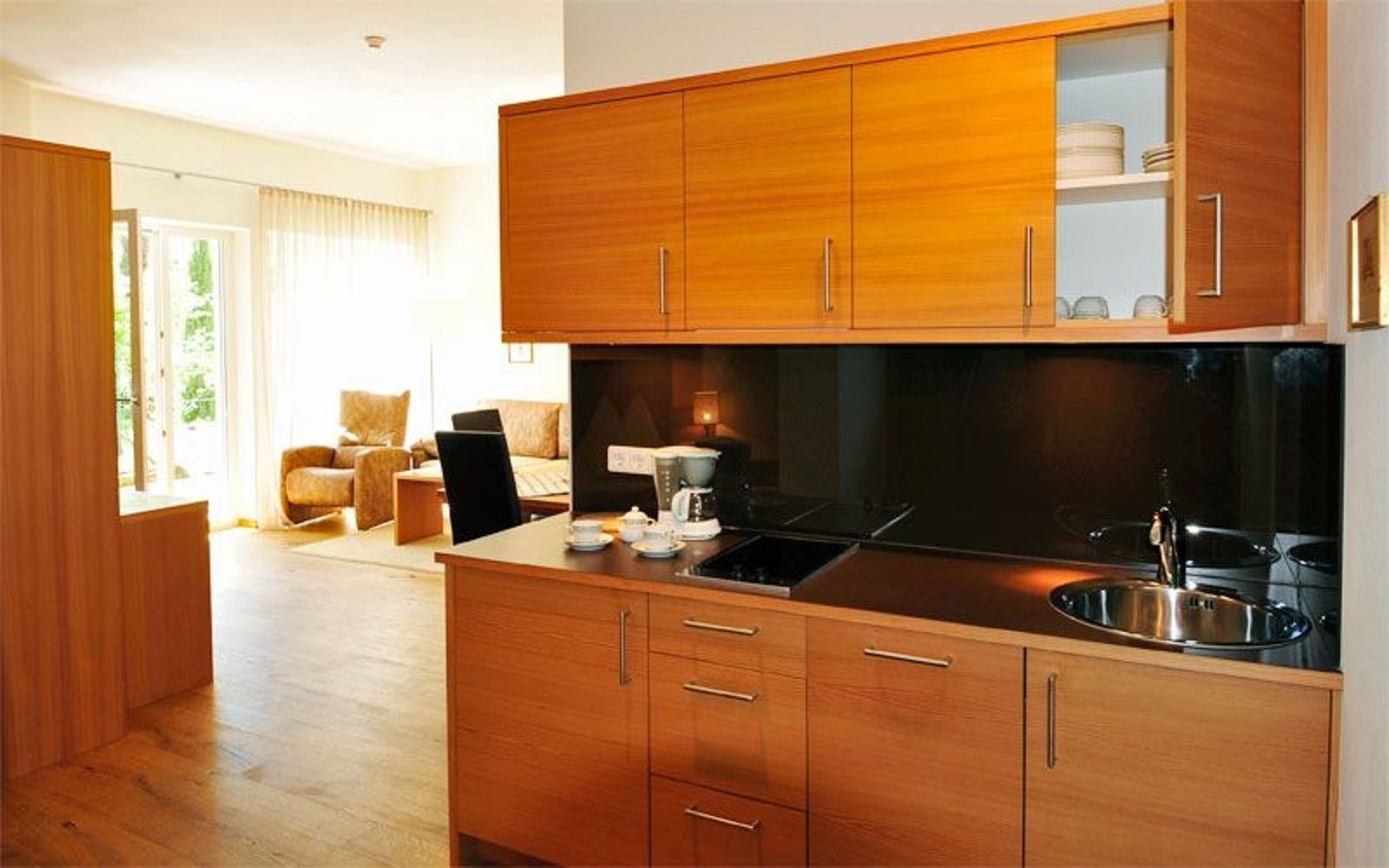 Una cocina moderna con gabinetes de madera, estufa integrada y un lavamanos.