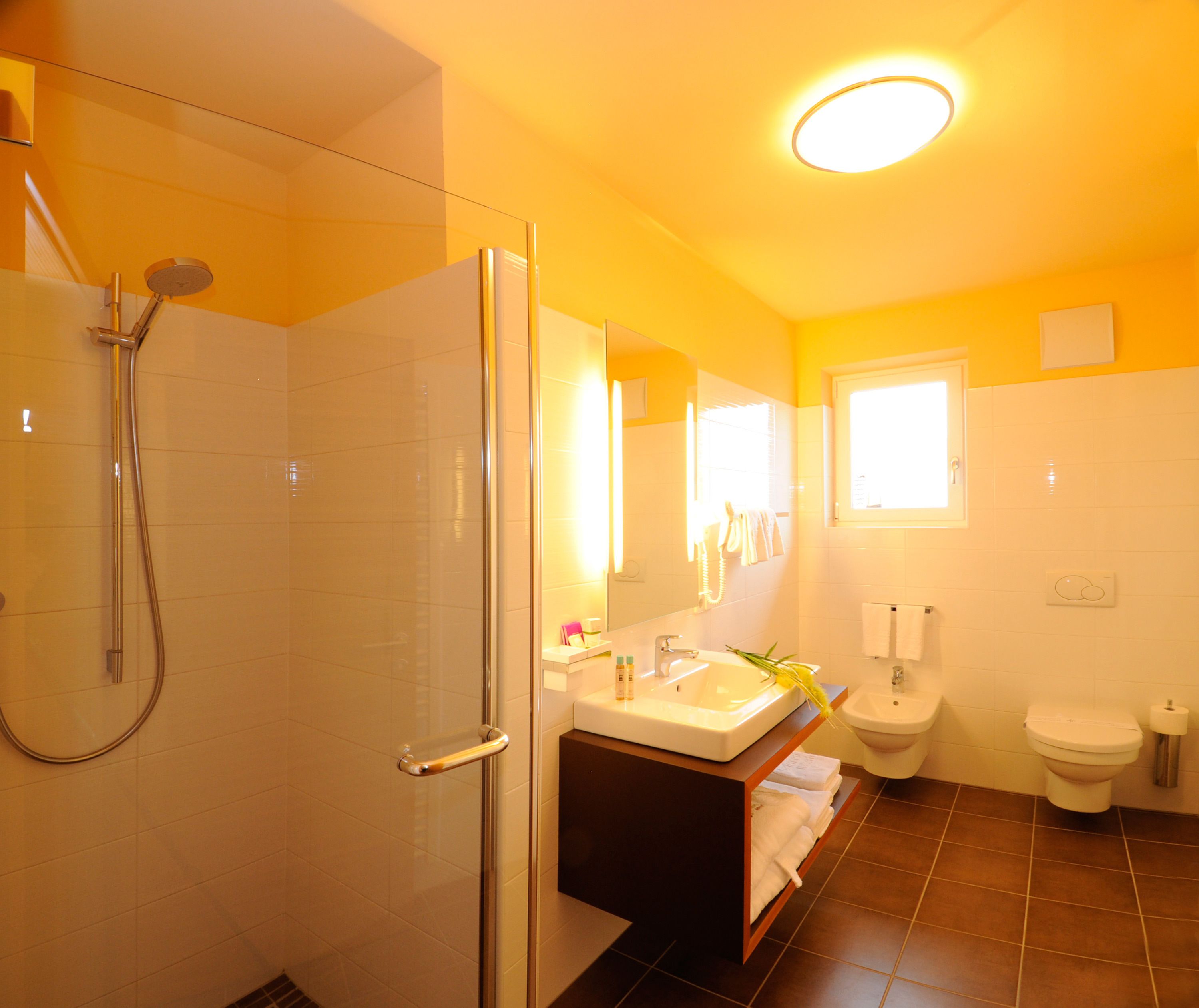 Ein Badezimmer mit Dusche, Waschbecken und Toilette.