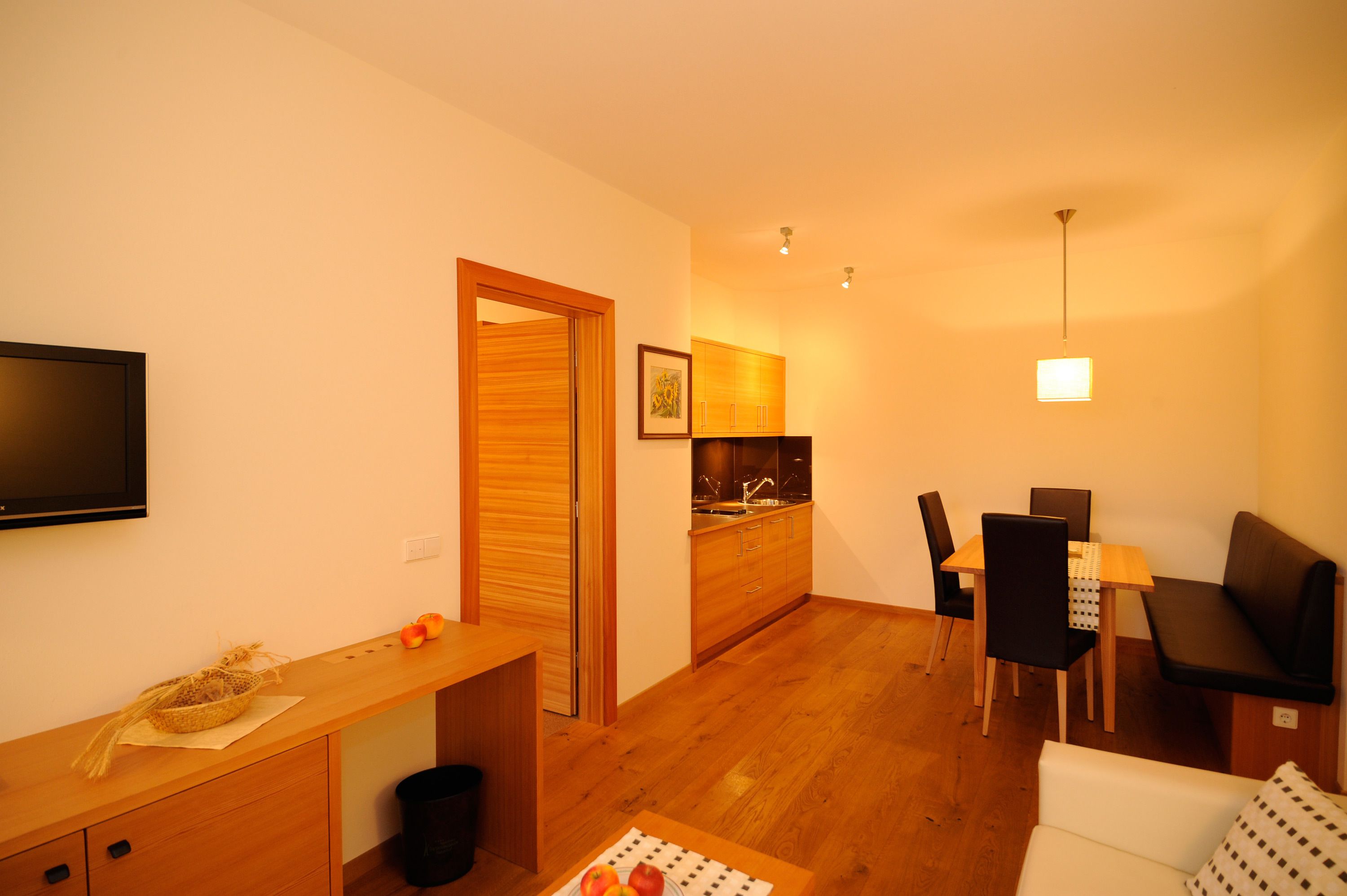 A compact living space with a kitchenette, a dining area, and a seating area.