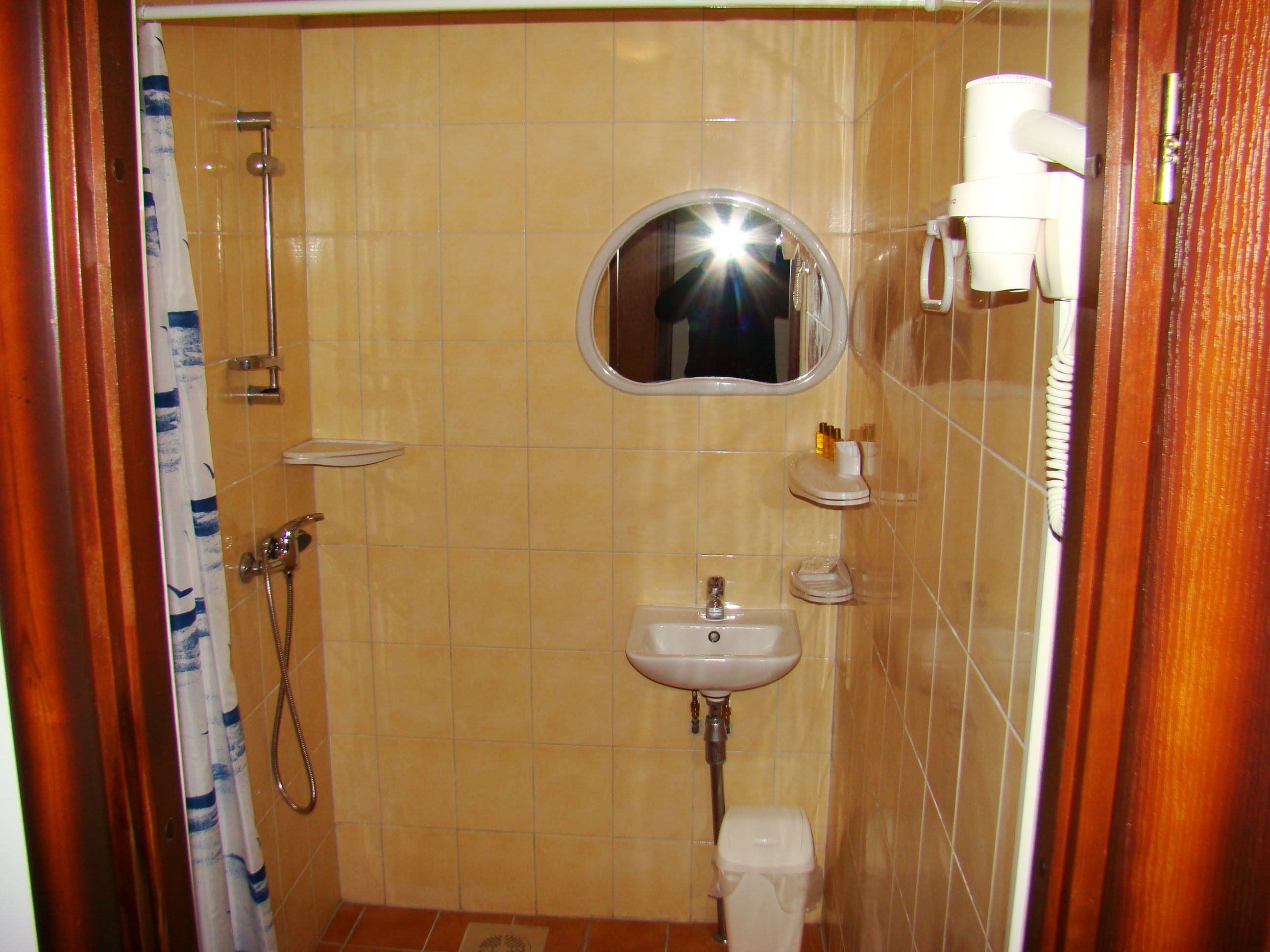 Kylpyhuone, jossa on suihku, pesuallas, wc ja peili.