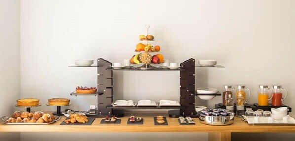 A breakfast buffet with various pastries, fruits, and beverages. - Netum Hotel (Noto)