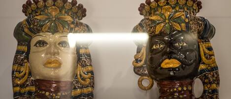 Dos figuras de cerámica ornamentadas con diseños intrincados y una superficie reflectante en el medio.