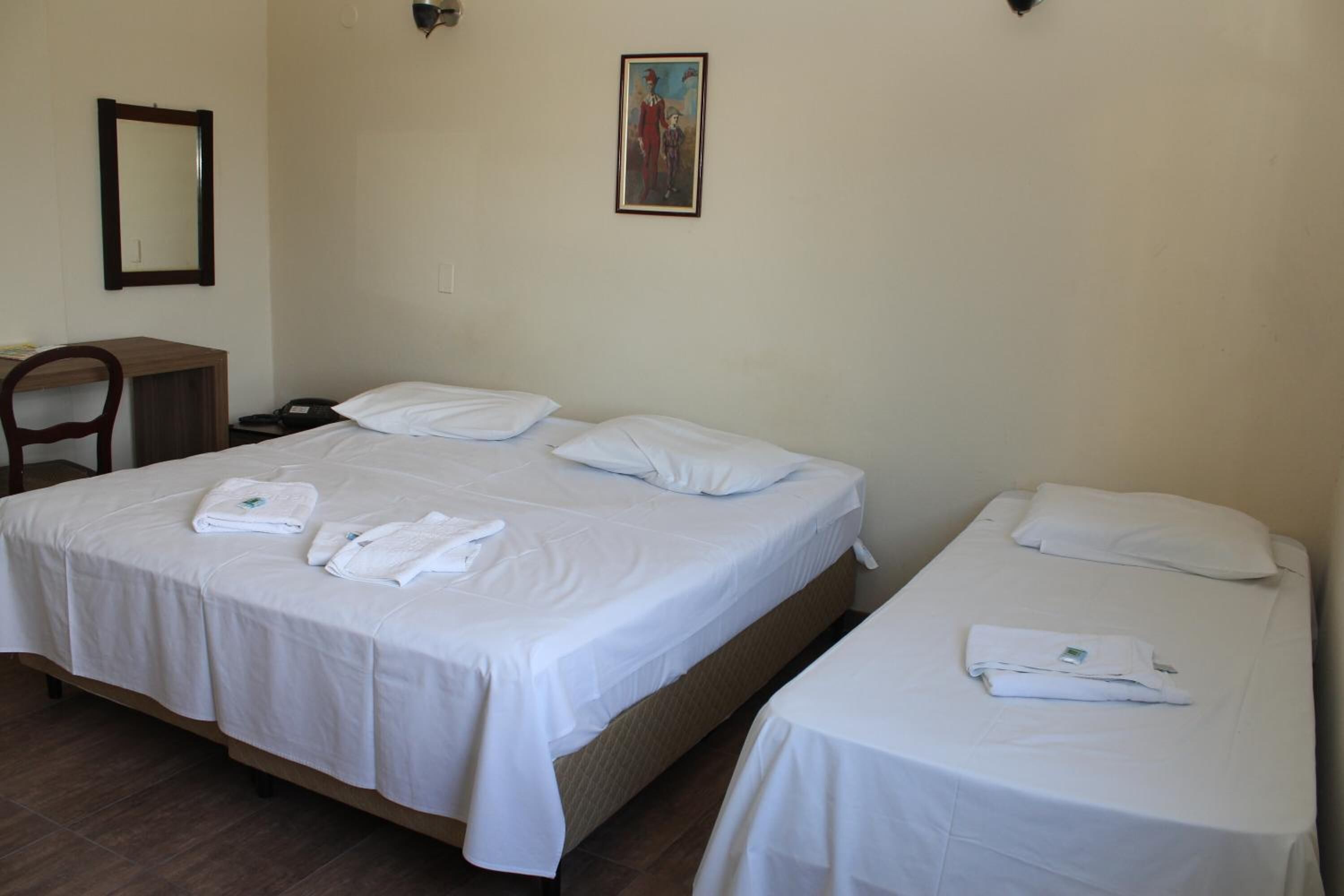 Una habitación de hotel con dos camas, un escritorio y una silla.