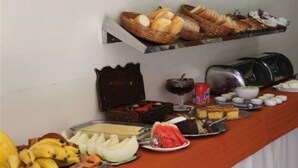 A buffet with various food items including bread, fruits, and desserts. - Espigão Palace Hotel (Resende)