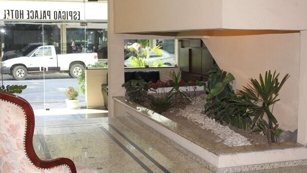 A reception area with a bench, a small garden with plants, and a sign for the "ESPICADO PALACE HOTEL". - Espigão Palace Hotel (Resende)
