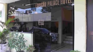 The exterior of Espigão Palace Hotel with a glass entrance, potted plants, and a visible car parked outside. - Espigão Palace Hotel (Resende)