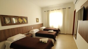 A hotel room with three beds, a TV, and a framed botanical artwork on the wall. - Hotel La Ponsa Itatiaia (Itatiaia)