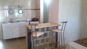 Una cocina con barra, pileta y estufa.