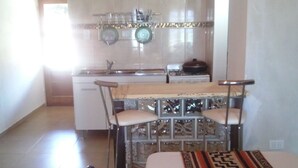 Una cocina compacta con comedor, que incluye una mesa y sillas.