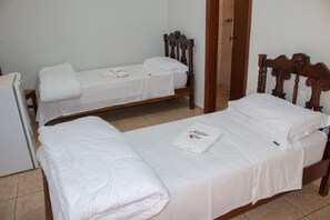 A room with two single beds, each with a wooden headboard and white bedding. - Hotel Jeremias (Barretos)