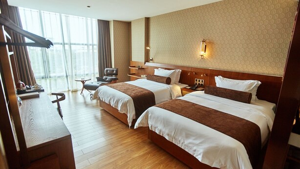 A hotel room with two beds, a desk, a chair, a TV, and a large window. - James Joyce Coffetel Qifu Xincun Branch (Guangzhou)