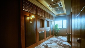 A hallway with wooden paneling, a patterned carpet, and a potted plant. - James Joyce Coffetel Qifu Xincun Branch (Guangzhou)