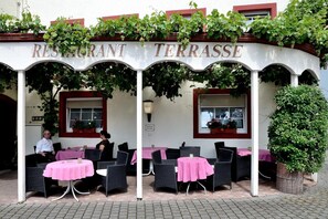 A restaurant terrace with outdoor seating, covered by a pergola with vines, and a sign reading "RESTAURANT TERRASSE". - Hotel Zum Josefshof (Graach)