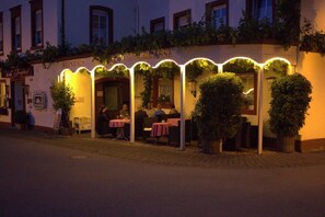 A restaurant with outdoor seating, covered by a canopy with lights, and a sign reading "WEINHAUS TERRASSE". - Hotel Zum Josefshof (Graach)