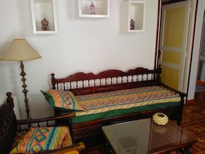 A room with a wooden bed, a table with a glass top, and a lamp. - Parent house (Hammamet)