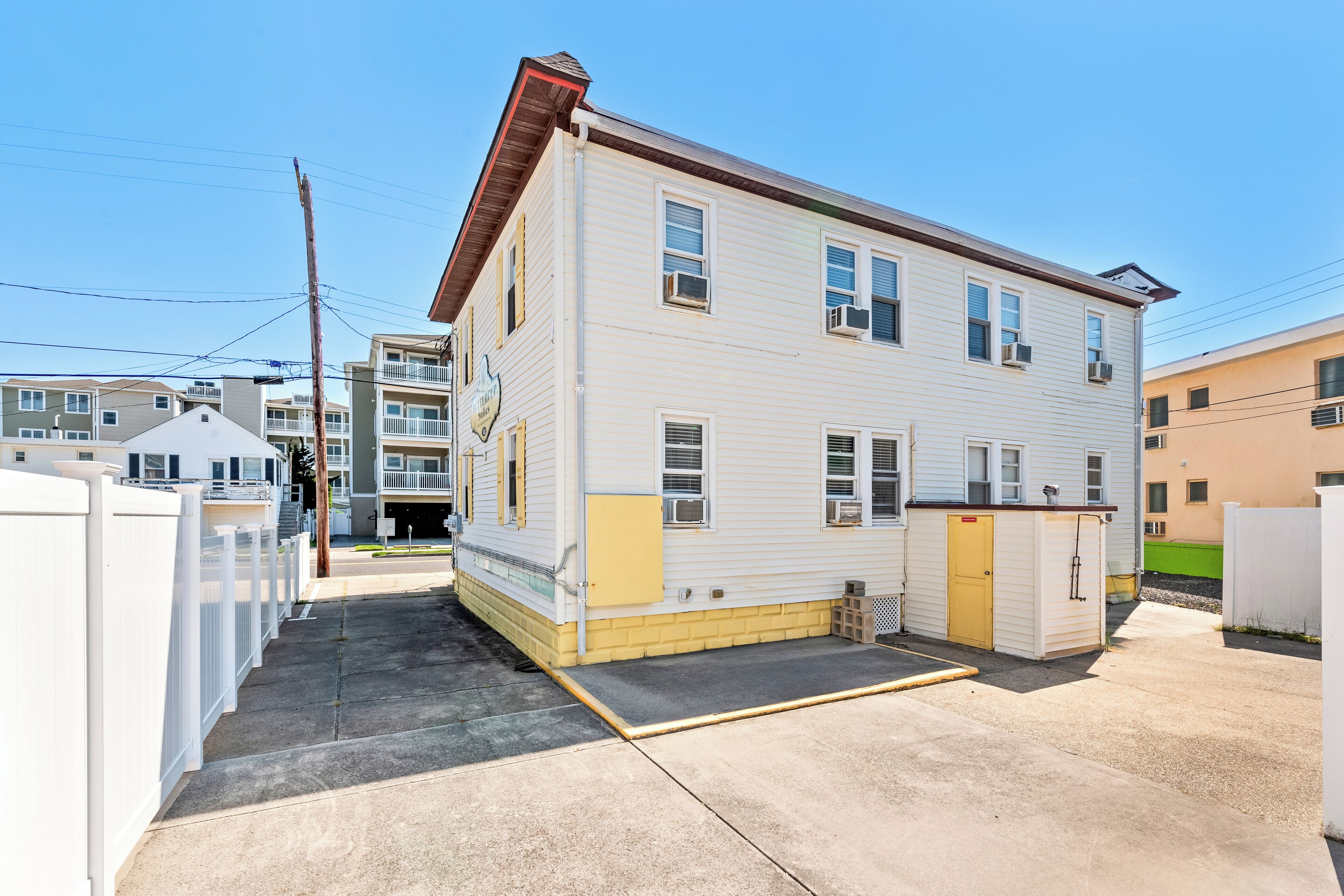 A two-story building with a flat roof and a small attached garage.