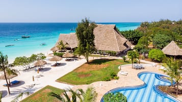 Een buitenzwembad, parasols voor strand/zwembad