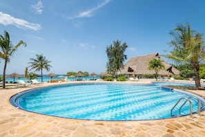 Alberca al aire libre, sombrillas en la alberca y camastros