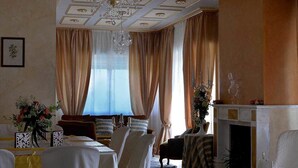 Una sala da pranzo formale con un lampadario, un camino e un tavolo apparecchiato per un pasto.
