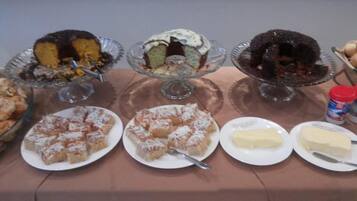 Una mesa de buffet con diversos postres y bandejas de queso.