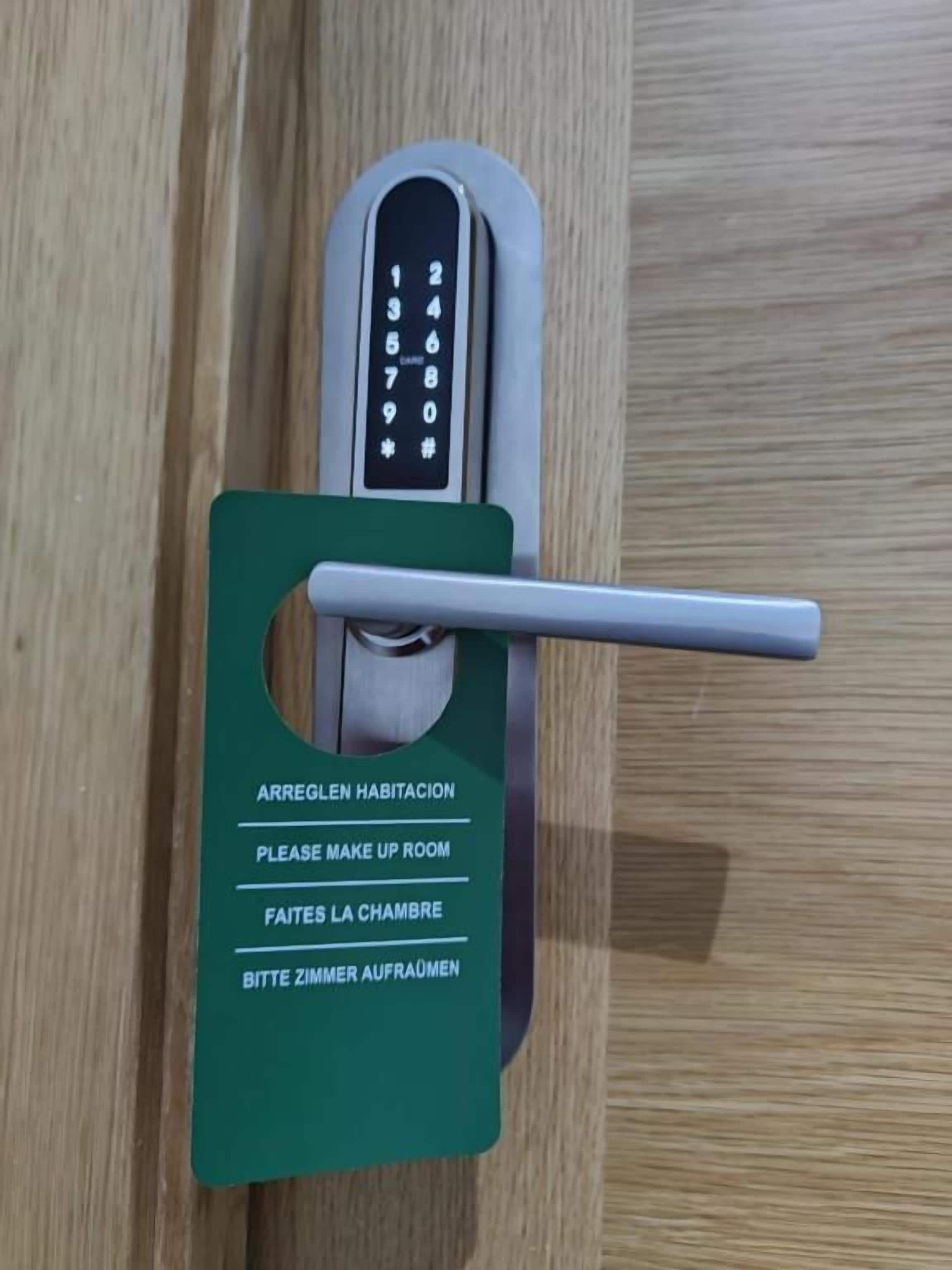 Una cerradura con un orificio para llave y una tarjeta con instrucciones multilingües para acceder a la habitación.