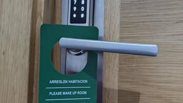 Una cerradura con un orificio para llave y una tarjeta con instrucciones multilingües para acceder a la habitación.