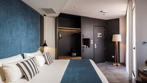 A modern hotel room with a large bed, a wardrobe, a desk, and a lamp. - Urban Rooms By Neu Collective (Gzira)