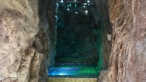 A narrow staircase with mosaic steps leading up to a platform with green lighting. - National Park Hotel & Spa (Cotronei)