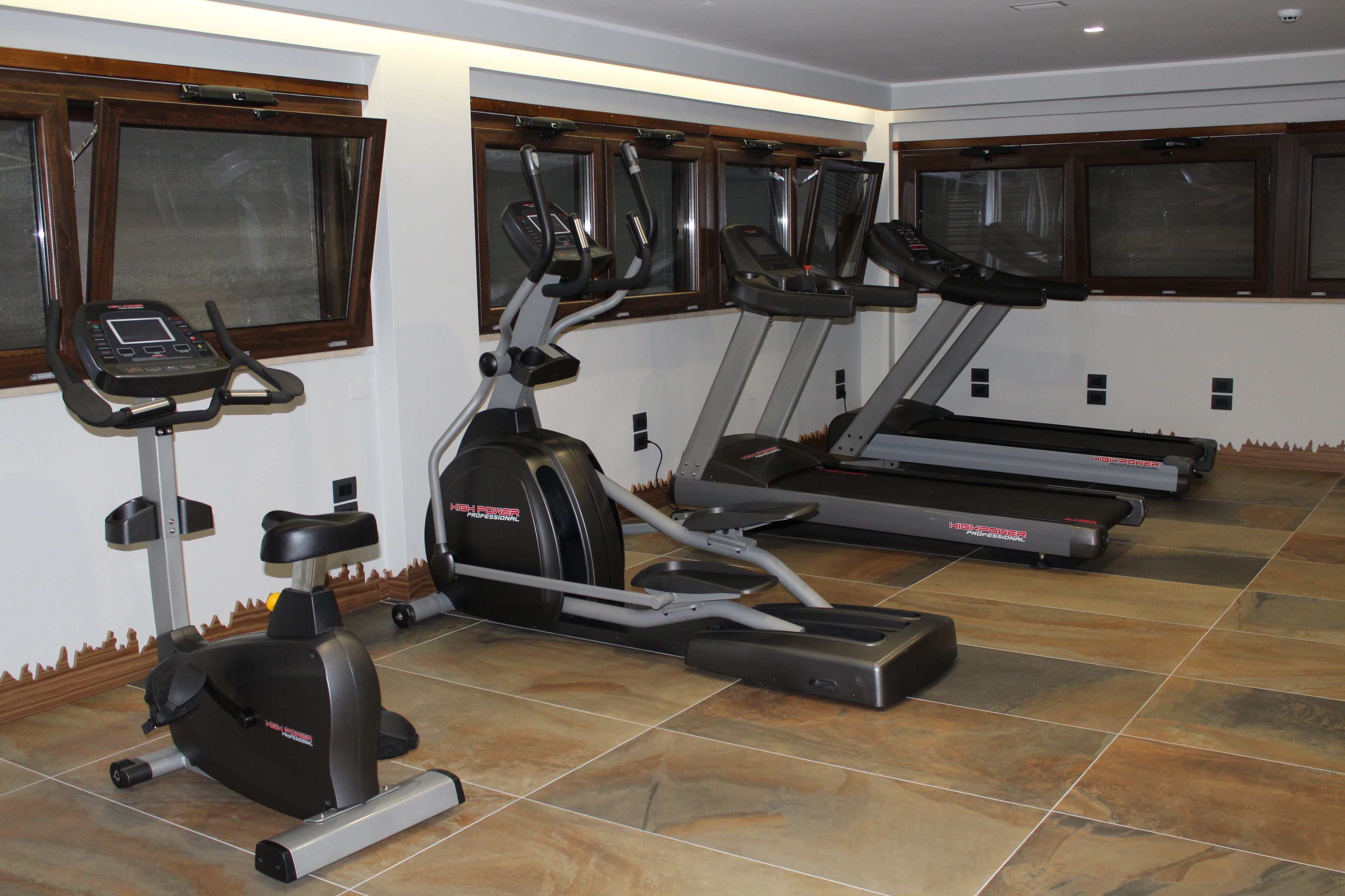 A gym with treadmills, elliptical machines, and a stationary bike.